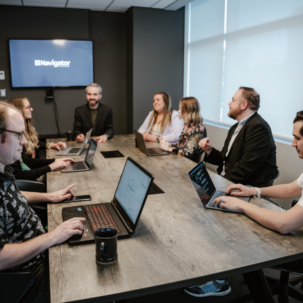 The Navigator Multimedia team having a meeting in the office boardroom, ready to help our clients succeed with graphic design, web development, online marketing, and general digital marketing support..