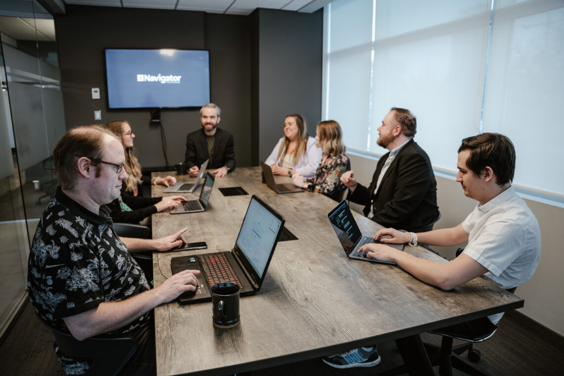 The Navigator Multimedia team having a meeting in the office boardroom, ready to help our clients succeed with graphic design, web development, online marketing, and general digital marketing support..