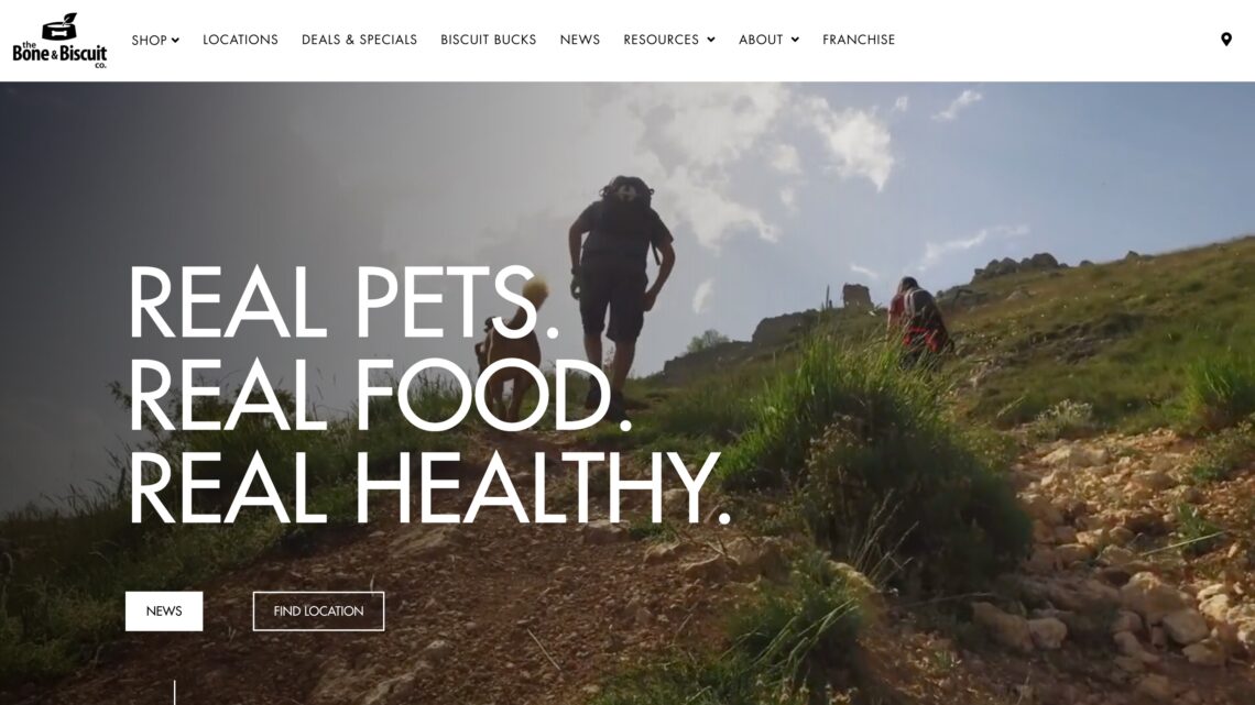 A screenshot of the Bone & Biscuit website homepage with a still photo of a video of a dog and its owner hiking in the sun, built by the Kelowna web design company and Kelowna Marketing Agency called Navigator Multimedia.